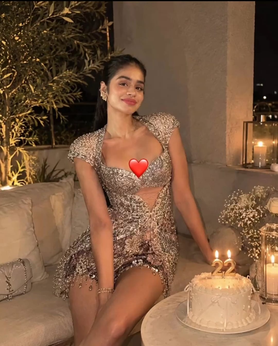 Didi beside a birthday cake, with the original heart sticker